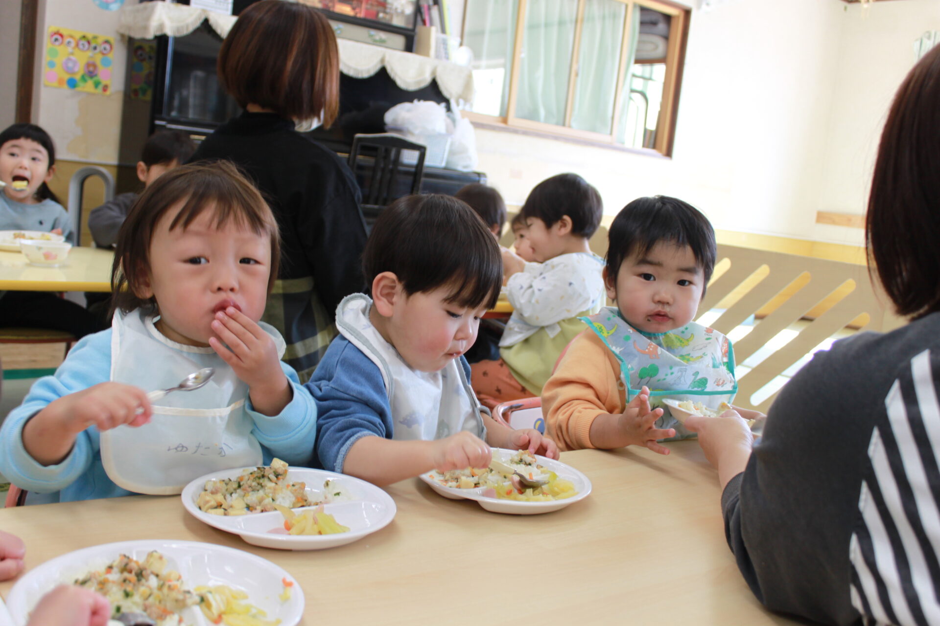 園児たちがそろってお昼ご飯を食べている様子の写真